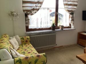 a living room with a couch and a window at Pension Krüger in Seeboden
