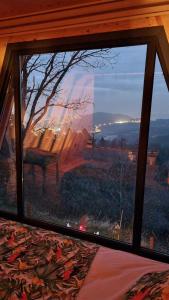 ein Fenster in einem Schlafzimmer mit Blick auf einen Baum in der Unterkunft HappyHouse Bungalov Three-Room, SPA pleasure with lake view, Sapanca B1 in Sapanca