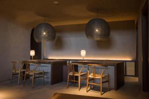 eine Bar mit Stühlen, 2 Tischen und 2 Leuchten in der Unterkunft nol hakone myojindai in Hakone