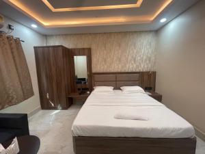 a bedroom with a large bed and a mirror at Hotel Dayaljeet in Jamshedpur