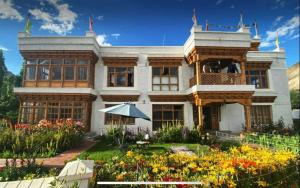 a large house with flowers in front of it at Namra Villa in Leh