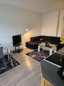 a living room with a couch and a tv at skyline flat with free parking in Lorenskog