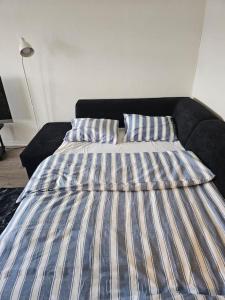 a bed with two pillows on it in a room at skyline flat with free parking in Lorenskog