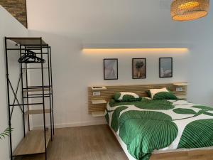 Un dormitorio con una cama con sábanas verdes y una escalera en Luna y Sol, en Valencia