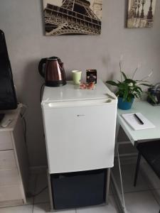 a desk with a tea kettle on top of a white refrigerator at Chambre chez l'habitant avec Sdb et WC privatifs in Marnay-sur-Seine