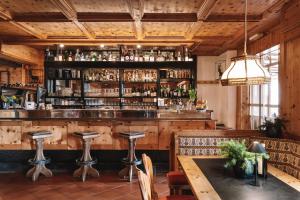 un bar en un restaurante con mesa y sillas en PLOSE Parkhotel & Residence, en Bresanona