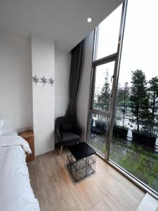 um quarto com uma cama e uma cadeira e uma grande janela em Star Deco Resort em Dongshan