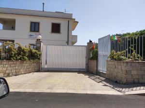 una recinzione bianca di fronte a una casa di B&B AMURI RANNI ad Avola