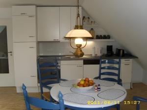 een keuken met een tafel met daarop een schaal fruit bij Fennas Ferienwohnungen - Hanne in Dornumersiel