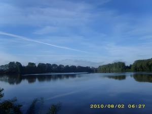 een grote hoeveelheid water met bomen op de achtergrond bij Fennas Ferienwohnungen - Hanne in Dornumersiel
