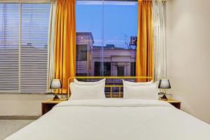 a bedroom with a large bed and a large window at Super OYO Palette - Pentagon Boutique Hotel in Jaipur