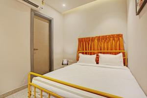 a bedroom with a bed with an orange curtain at Super OYO Palette - Pentagon Boutique Hotel in Jaipur