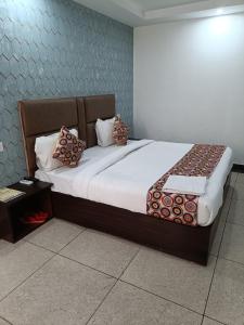 una camera da letto con un grande letto con cuscini sopra di Hotel Marina Near IGI Airport Delhi a Nuova Delhi