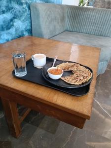 un tavolo con vassoio, pizza e bicchiere di Hotel Marina Near IGI Airport Delhi a Nuova Delhi