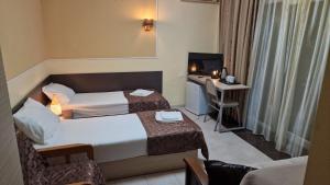 um quarto de hotel com duas camas e uma televisão em Karakum hotel em Ureki