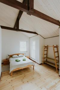 a bedroom with a bed and a wooden floor at LVM tūrisma un atpūtas centrs "Spāre" in Spāre
