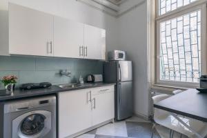 a kitchen with white cabinets and a washer and dryer at Raday Bobo in Budapest