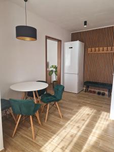 a kitchen with a table and chairs and a refrigerator at House of flowers in Petroşani