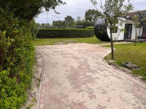 a driveway with a large tire next to a house at Tinyhouse Friesland 