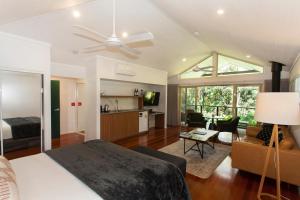 a bedroom with a bed and a living room at Songbirds Rainforest Retreat in Mount Tamborine