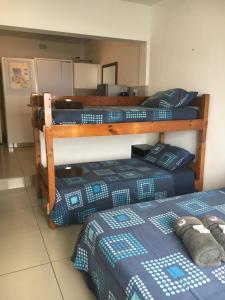2 letti in una camera con letti bianchi e blu di Umkomaas Lodge a Umkomaas