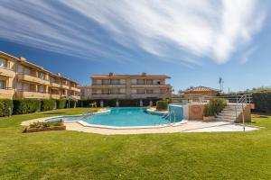 a swimming pool in front of a large building at Apartamento Tamarindos 500 in L'Estartit