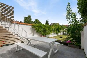 una mesa blanca y un banco en un patio con escaleras en Anny's Home - Spacious holiday home in city center en Brujas