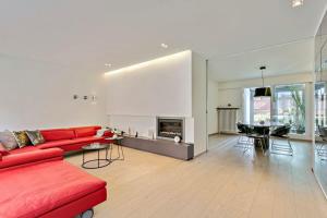 sala de estar con sofá rojo y chimenea en Anny's Home - Spacious holiday home in city center, en Brujas