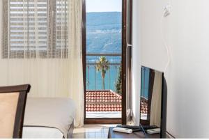 Habitación con cama y ventana con vistas. en Tea, en Herceg-Novi