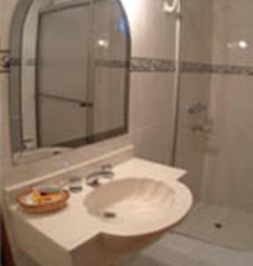 y baño con lavabo y ducha. en Hotel Portal del Sol en Asunción