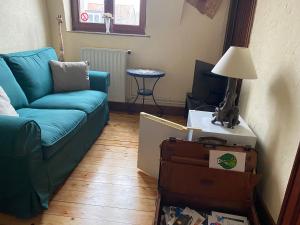 a living room with a couch and a table with a lamp at B&B Marianne in Brussels