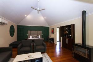 a living room with a bed and a couch at Songbirds Rainforest Retreat in Mount Tamborine