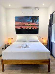a bedroom with a bed with a painting on the wall at Wild Monkeys Hostel in Moalboal