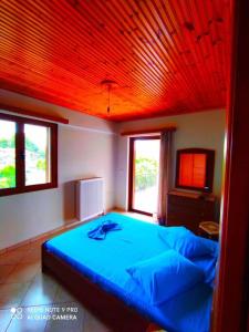 ein Schlafzimmer mit einem blauen Bett und einer roten Decke in der Unterkunft live the ultimate experience within nature in Zakharo