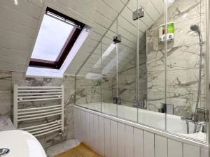 a bathroom with a tub and a sink and a window at Natalie’s Apartment in Wembley in London