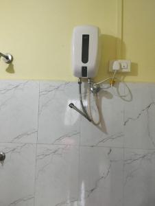La salle de bains est pourvue d'un sol en marbre et d'un téléphone mural. dans l'établissement Shri Krupa Homestay, à Diveagar