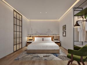 a bedroom with a white bed and a green chair at Citadines Connect East Chengdu in Xinsanchaba