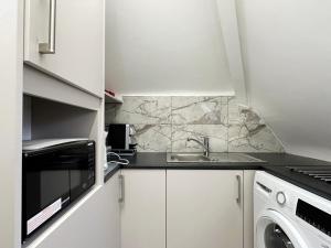 a kitchen with a sink and a microwave at Natalie’s Apartment in Wembley in London