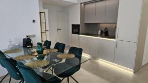 een eetkamer met een glazen tafel en stoelen bij Oasis jacuzzi retreat in Marbella