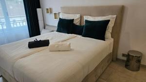 een slaapkamer met een groot wit bed met blauwe kussens bij Oasis jacuzzi retreat in Marbella +45 foto's