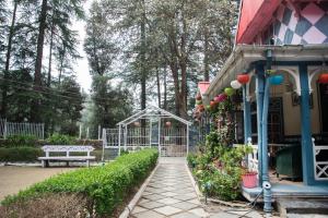 a garden with a gate and a bench next to a house at Heritage Villas - Shimla British Resort, Near Mall in Shimla