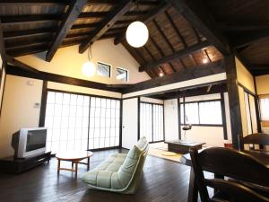 salon z kanapą i telewizorem w obiekcie Nagomiya Hirugano w mieście Gujo