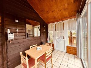 a wooden dining room with a table and a window at Au Chalet d'Aline - Atypique pour 4 personnes in Gérardmer