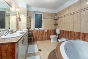 bagno con 2 lavandini, vasca e servizi igienici di Moderne Ferienwohnung in Kaldanija mit Großer Terrasse a Kaldanija