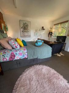 Schlafzimmer mit einem Bett und einem Schreibtisch mit einem Laptop in der Unterkunft Enchanted Retreat in Morwell