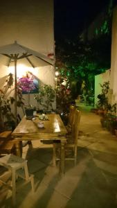 une table et des chaises en bois avec un parasol dans l'établissement Casa Antica, à Rhodes