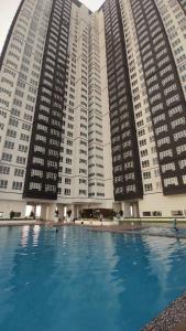 een groot gebouw met een groot zwembad ervoor bij Amber Cove Malacca City View in Melaka