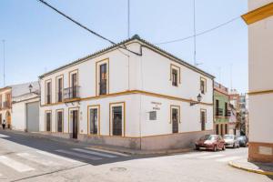 un edificio blanco al lado de una calle en La Casa del Cura 1935, en Alcalá de Guadaira