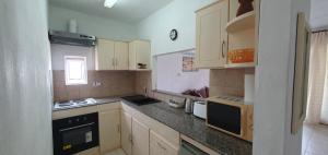 a kitchen with white cabinets and a counter top at Beachfront Pereybere - Azur Beach Complex in Pereybere