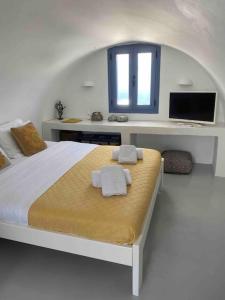 una camera da letto con un letto con due asciugamani sopra di Dome suite,hot tub,sea view in Firostefani! a Firà